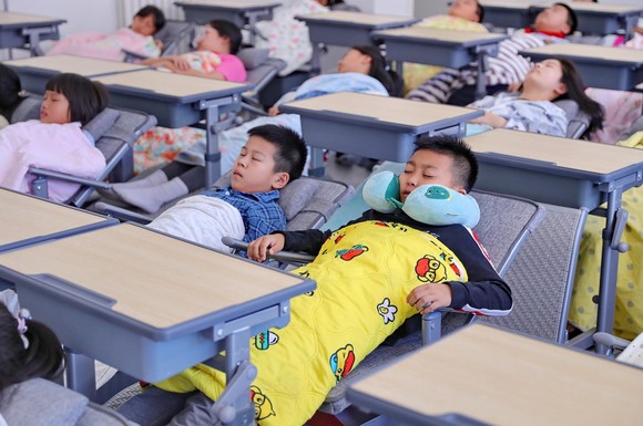 Bàn của học sinh Trung Quốc có thể kéo ra thành giường ngủ.