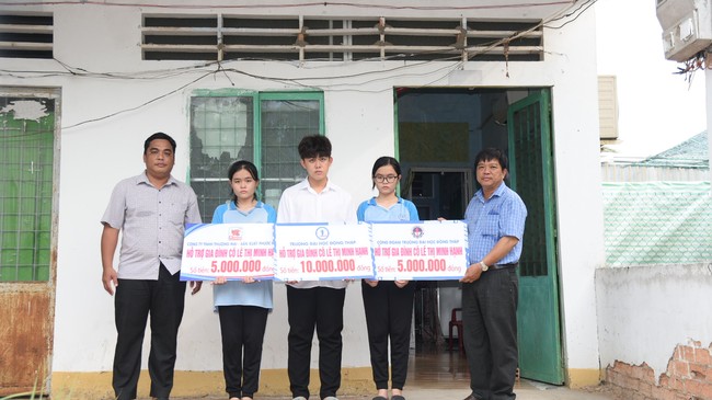 Đại diện Trường ĐH Đồng Tháp trao tặng số tiền động viên, tiếp sức gia đình cô Hạnh.