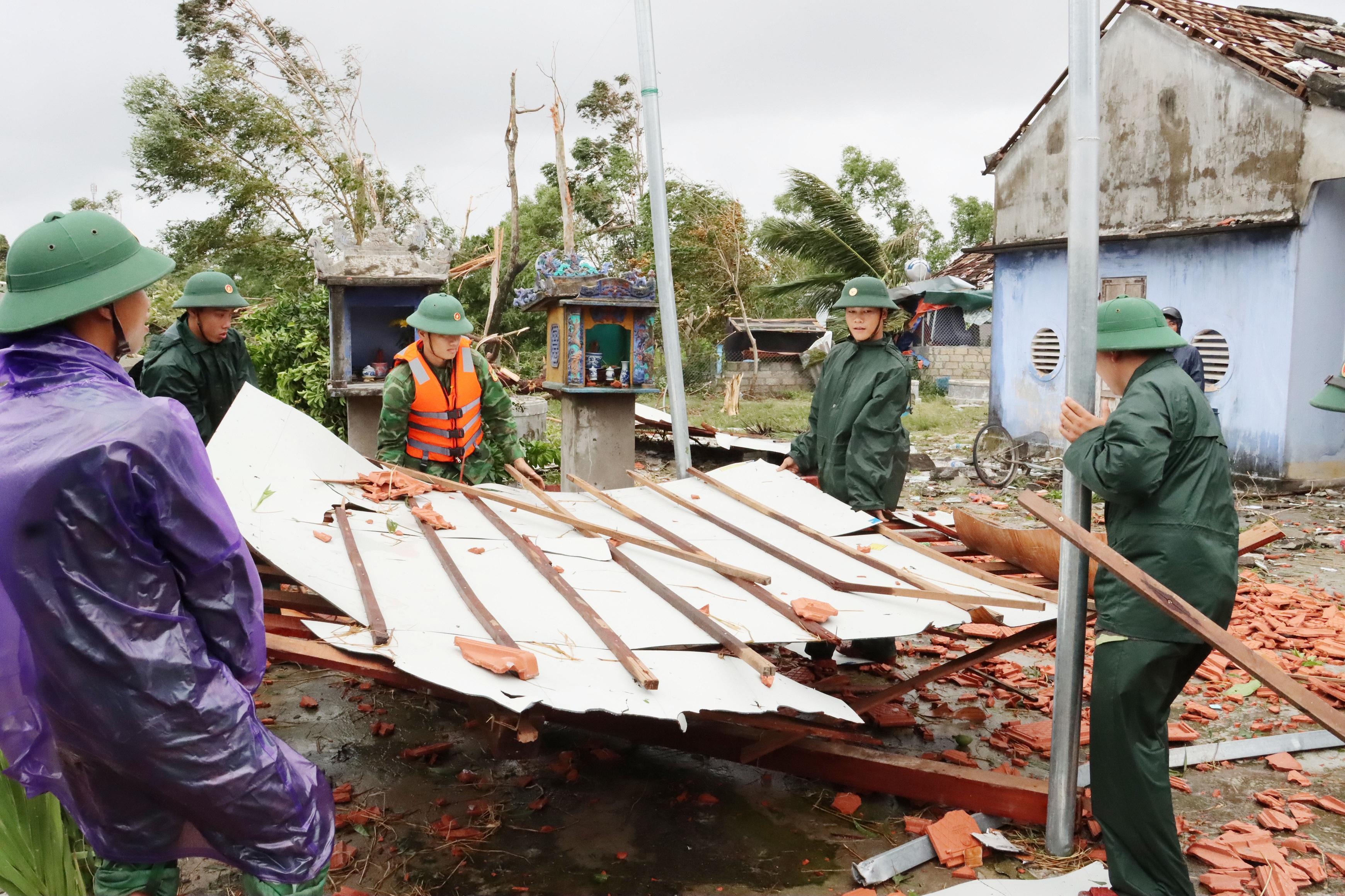 Các chiến sĩ quân đội tỉnh Thừa Thiên - Huế giúp người dân xã Vinh Xuân, huyện Phú Vang dựng lại nhà cửa bị sập, tốc mái sau bão số 4. (Ảnh: Trần Tình).