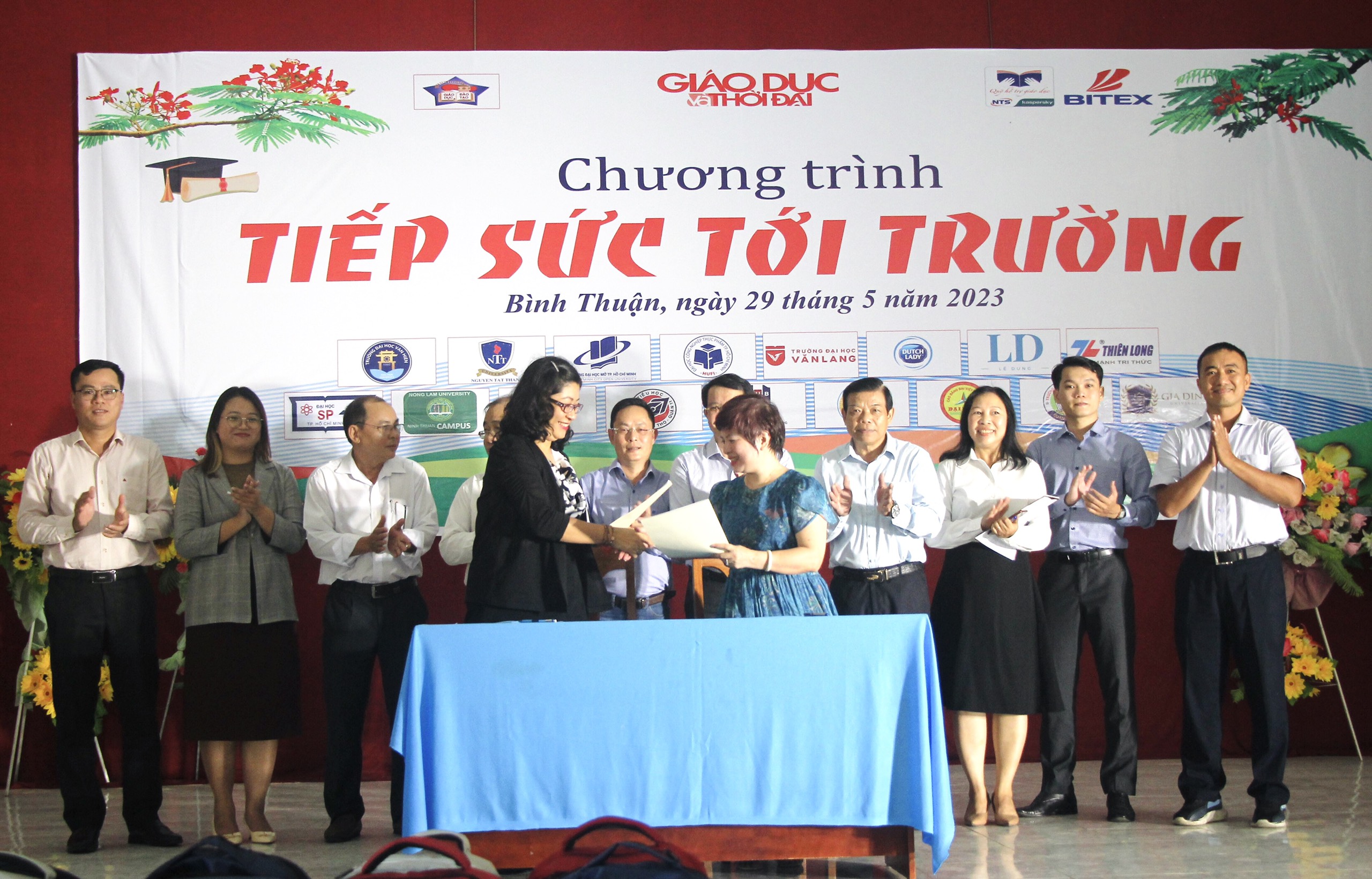 Nhà báo Dương Thanh Hương và bà Nguyễn Thị Phương An trao văn bản ký kết.
