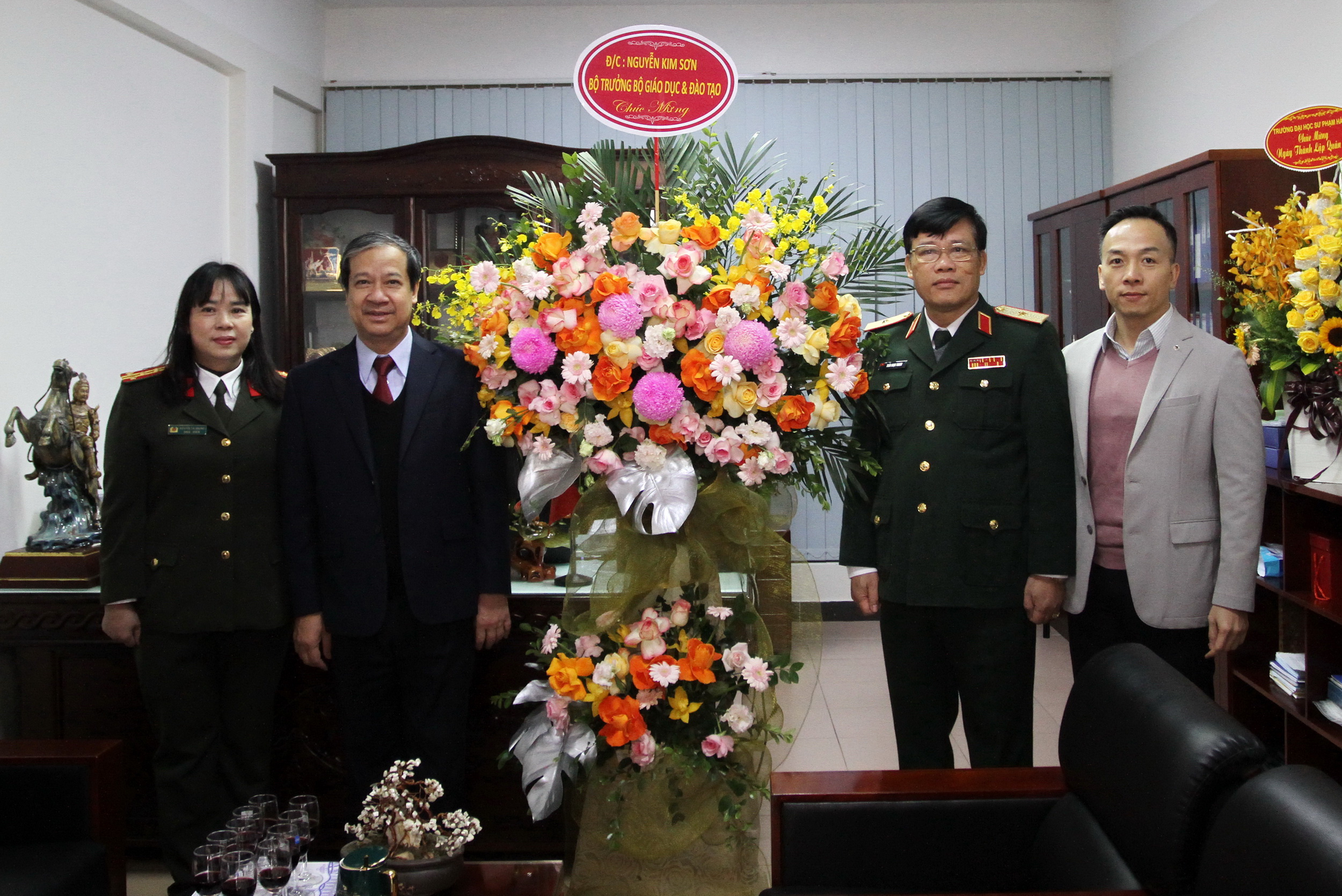 Bộ trưởng Nguyễn Kim Sơn tặng hoa chúc mừng tập thể Vụ Giáo dục Quốc phòng và An ninh.