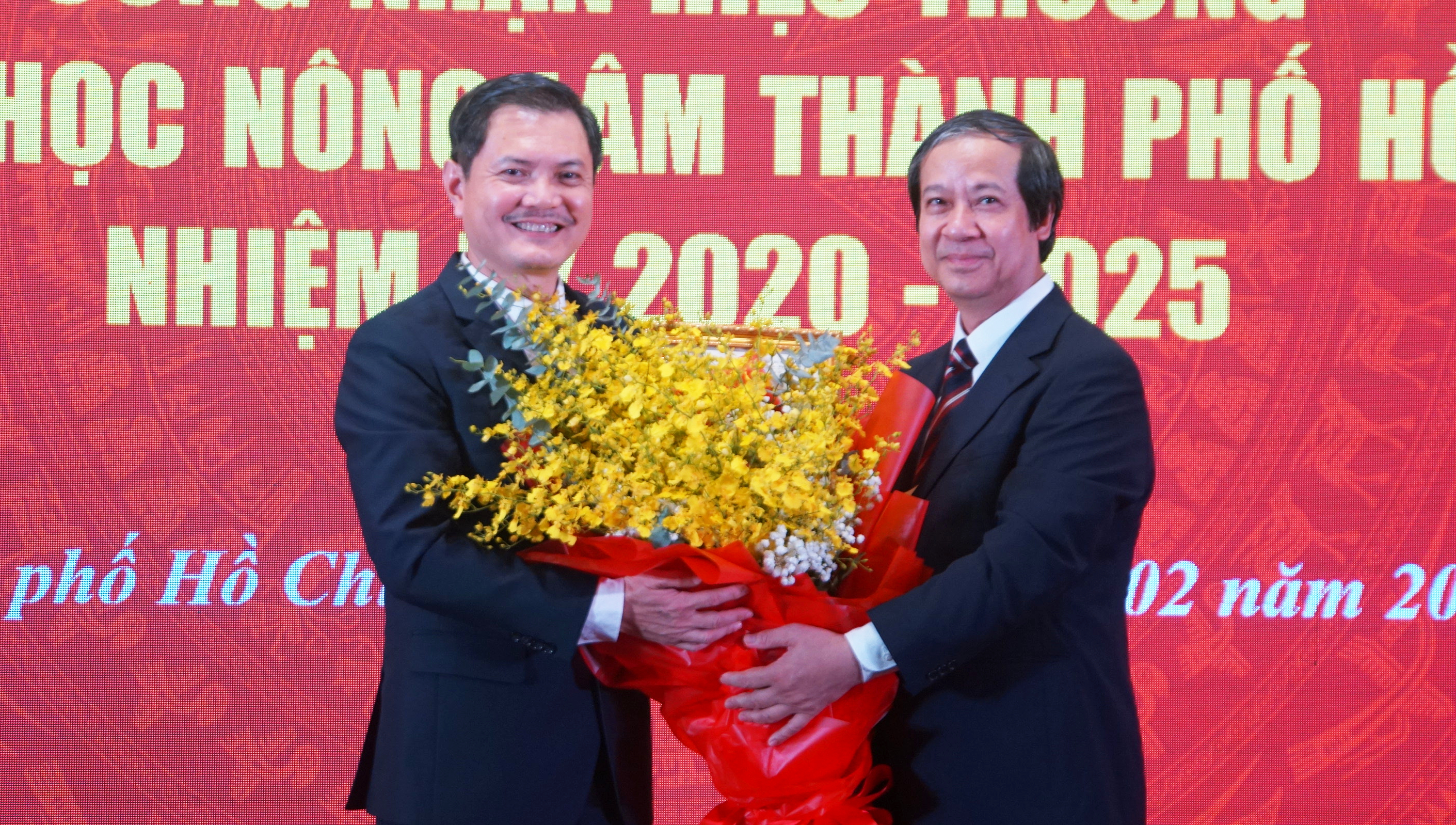 Bộ trưởng Nguyễn Kim Sơn (phải) tặng hoa chúc mừng PGS.TS Nguyễn Tất Toàn. Ảnh: Mạnh Tùng