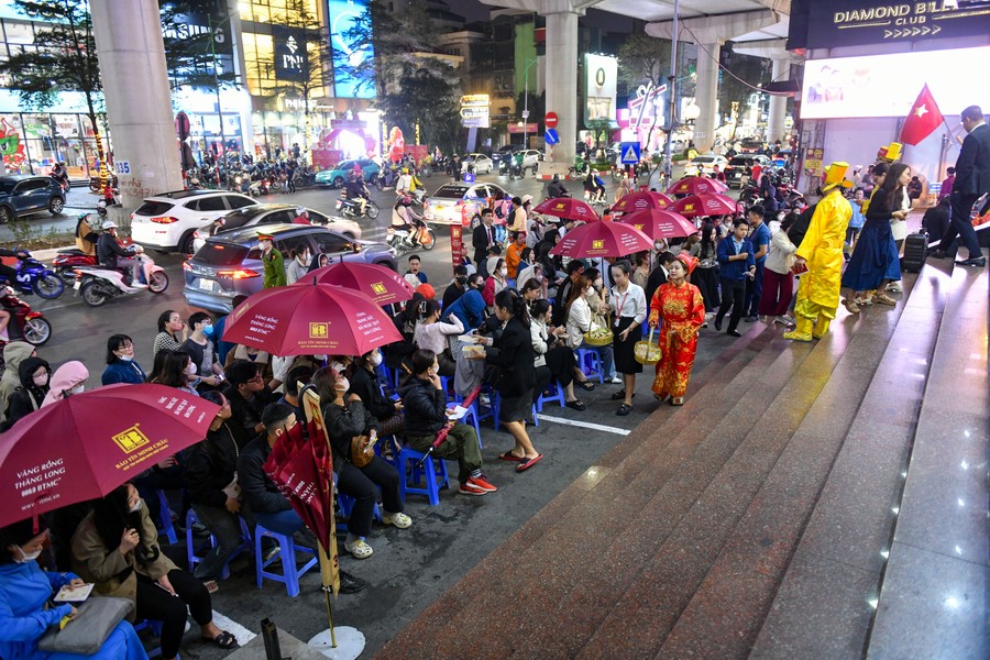 Người dân đội mưa, xếp hàng trong đêm chờ mua vàng ngày vía Thần Tài