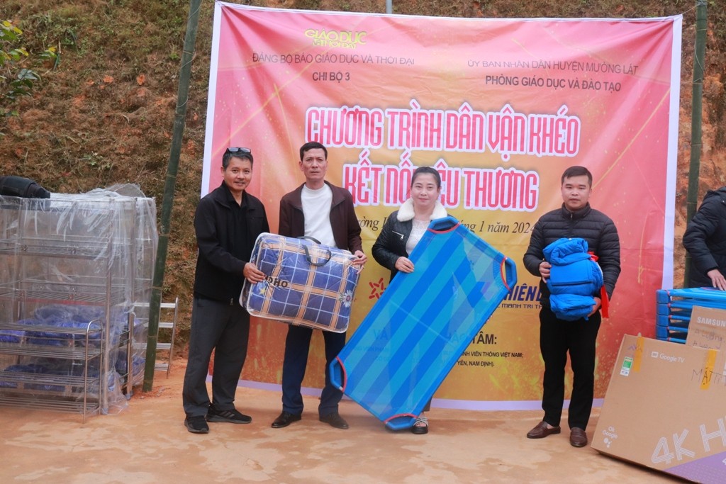 Phó Tổng biên tập Nguyễn Đức Tuân (ngoài cùng bên trái) trao tượng trưng một số phần quà cho hiệu trưởng 2 nhà trường. Ảnh: TL