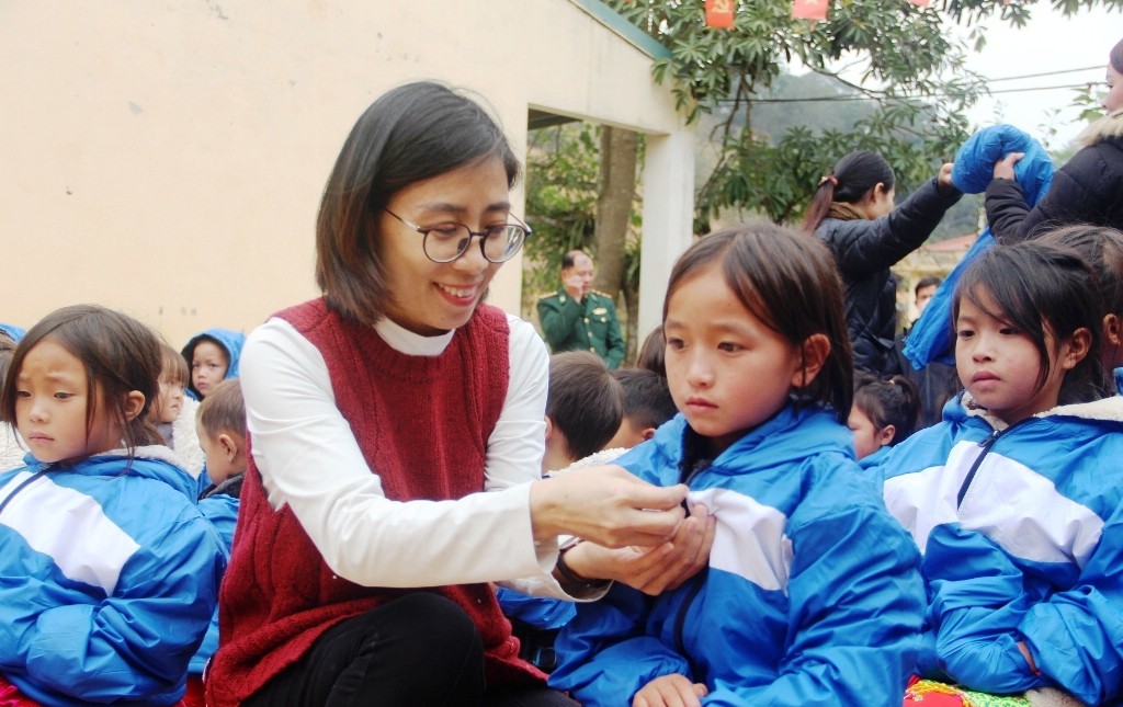 Nhà báo Trần Thị Ngọc Nam, Chủ tịch Công đoàn Báo GD&TĐ trao áo ấm cho học sinh. Ảnh:TL