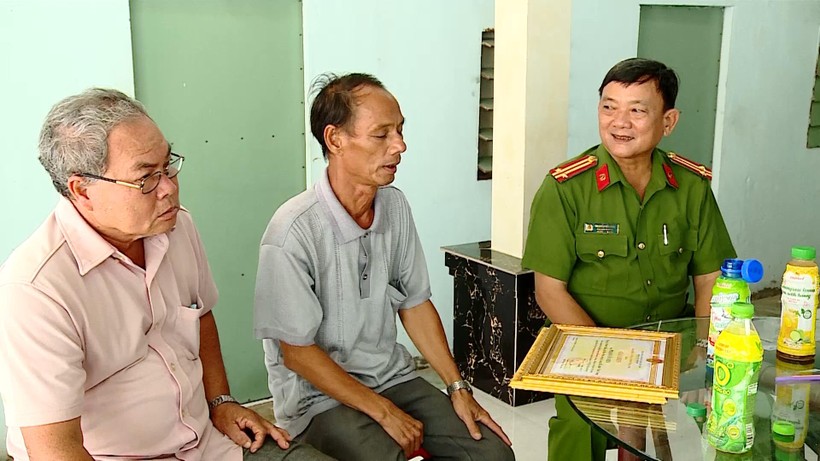 Ông Phạm Văn Diệu (giữa) được công an trao tặng bằng khen vì đã có thành tích trong phong trào Toàn dân tham gia bảo vệ an ninh Tổ quốc .
