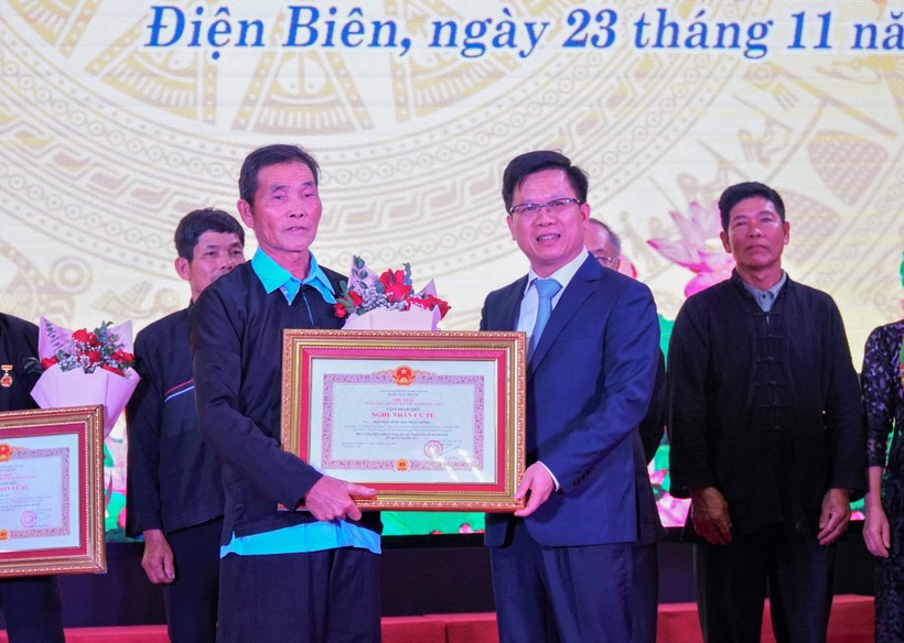Thừa ủy quyền của Chủ tịch nước, ông Phạm Đức Toàn (bên phải), Phó Chủ tịch Thường trực UBND tỉnh Điện Biên trao tặng danh hiệu cho các Nghệ nhân ưu tú.