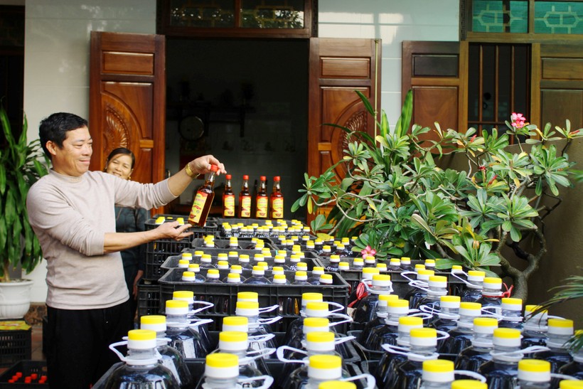Ông Lê Xuân Tôn cùng vợ vui mừng khi hàng trăm chai mắm thơm ngon đã được đóng chai, chuẩn bị lên đường phục vụ Tết.