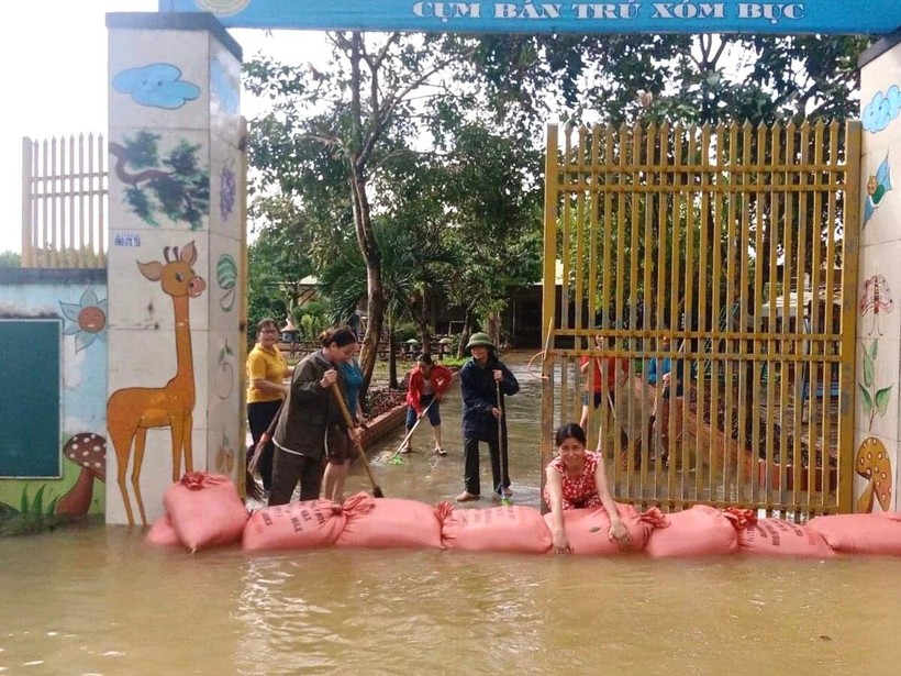 Giáo viên cụm xóm Bục, Trường Mầm non Đồng Văn 2 (huyện Tân Kỳ, Nghệ An) dùng bao cát ngăn không cho nước lũ tràn vào sân.
