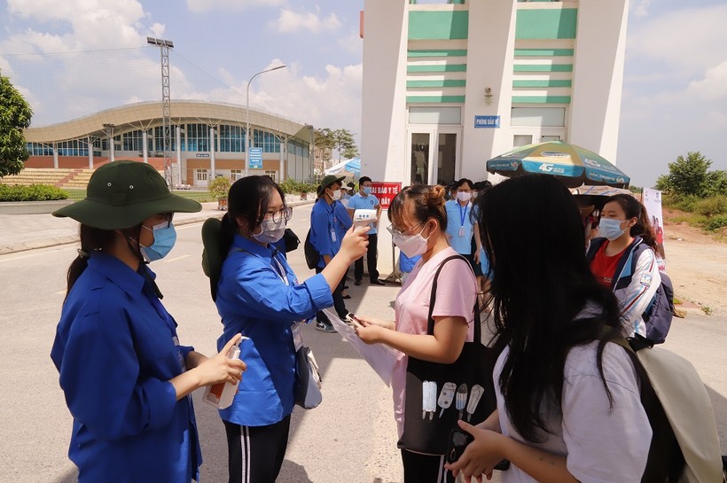 Hỗ trợ lực lượng y tế đo thân nhiệt tại điểm thi trường THPT Chuyên Thái Nguyên.
