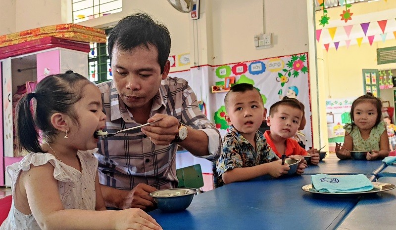 Thầy giáo Trường Mầm non Thành Sơn (Bá Thước, Thanh Hóa) cho trẻ ăn trưa tại trường.