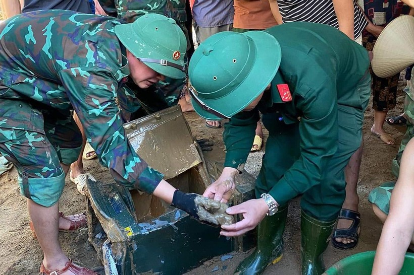 Lực lượng quân sự tìm được chiếc két sắt vùi lấp trong đất đá.