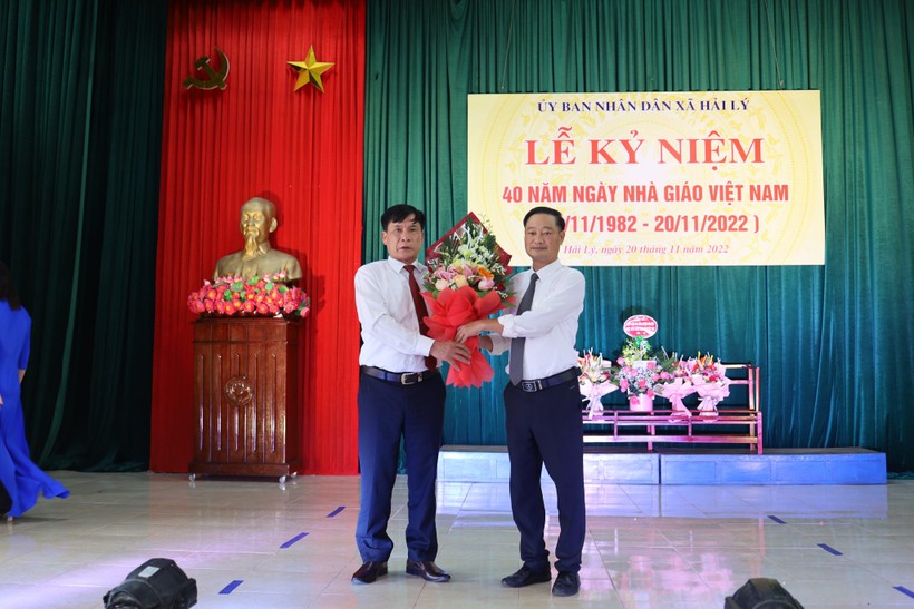Ông Vũ Viết Văn (trái) - Nguyên Bí thư Đảng ủy xã Hải Lý tặng hoa chúc mừng tại buổi lễ.