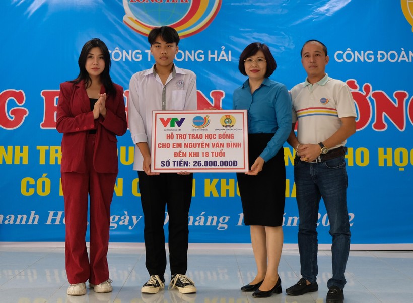 Bà Đặng Hoàng Anh (thứ 2 bìa phải) cùng đại diện Quỹ tấm lòng Việt, nhà tài trợ trao học bổng tới em Nguyễn Văn Bình.