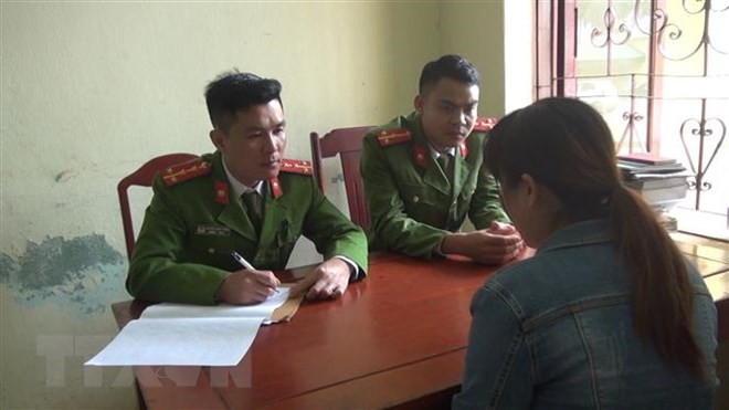 Lực lượng công an tuyên truyền người dân xã Quảng Nham không xuất cảnh trái phép. (Ảnh: Trịnh Duy Hưng/TTXVN).
