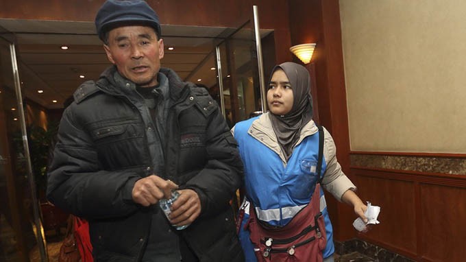 Người thân của một hành khách trên chuyến bay MH370 sốt ruột đi lại trong hành lang khách sạn ở Bắc Kinh - Ảnh: Reuters