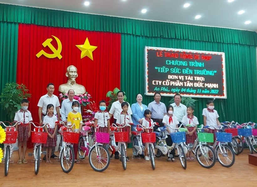 Đại diện chính quyền địa phương và công ty cổ phần Tân Đức Mạnh (TPHCM) trao tặng 66 chiếc xe đạp cho học sinh.