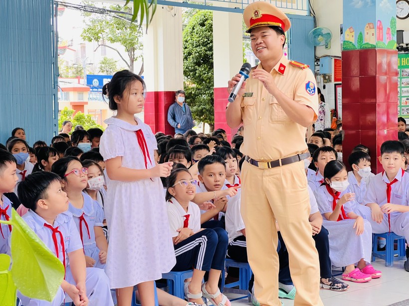 Trung tá Võ Hoàng Sang, Phó Trưởng Phòng CSGT (CATP Cần Thơ) hướng dẫn học sinh tham gia giao thông an toàn tại buổi tuyên truyền. ảnh 1