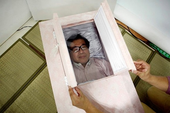Một người đàn ông Nhật Bản nằm vào quan tài trong đám tang giả của chính ông tại thành phố Tokyo hôm 24/10. Ảnh: Reuters
