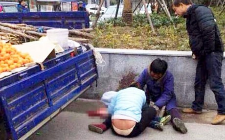 Hai vợ chồng người bán hoa quả đang ôm con khóc trên đường phố Hàng Châu. (Ảnh: SCMP)