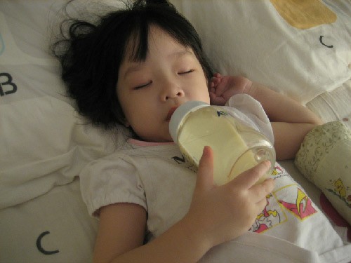 Trẻ bú nằm có thể gây trào ngược thực quản (ảnh minh họa Sg.theasianparent.com)