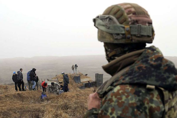 Một người lính đang nhìn ra phía người dân Ukraine đang đào hào trên bờ biển Azov