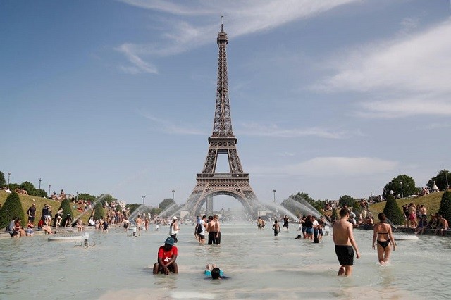 Mọi người thư giãn trong Đài phun nước Trocadero trước Tháp Eiffel ở Paris vào thứ Sáu