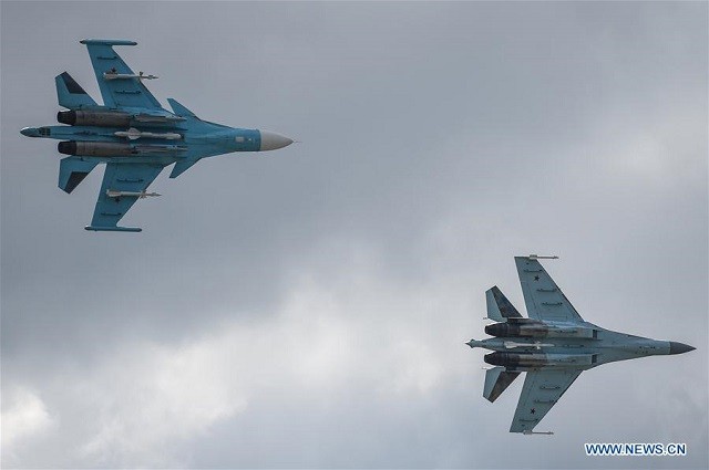 Chiến đấu cơ Su-34 (trái) và Su-35 trình diễn trong buổi triển lãm hàng không vào ngày khai mạc.