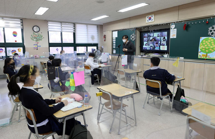 Một GV vừa dạy trực tuyến vừa dạy trực tiếp ở một trường học tại Seoul.