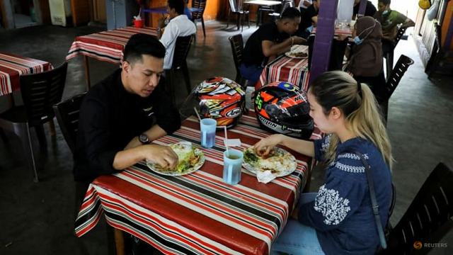 Người được tiêm chủng đầy đủ dùng bữa tại một nhà hàng, giữa lúc bùng phát COVID-19 ở Kuala Lumpur, Malaysia.