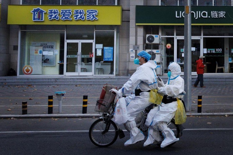 Nhân viên phòng chống đại dịch trong bộ đồ bảo hộ đi xe đạp điện khi dịch bệnh do COVID-19 tiếp tục bùng phát ở Bắc Kinh. Ảnh: Reuters.