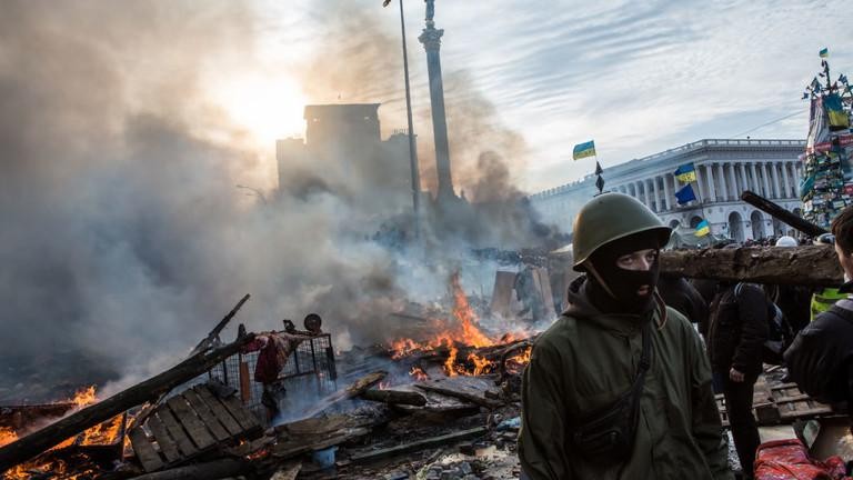 Người biểu tình chống chính phủ đi giữa đống đổ nát gần Quảng trường Độc lập ở Kiev, Ukraine, ngày 19/2/2014.