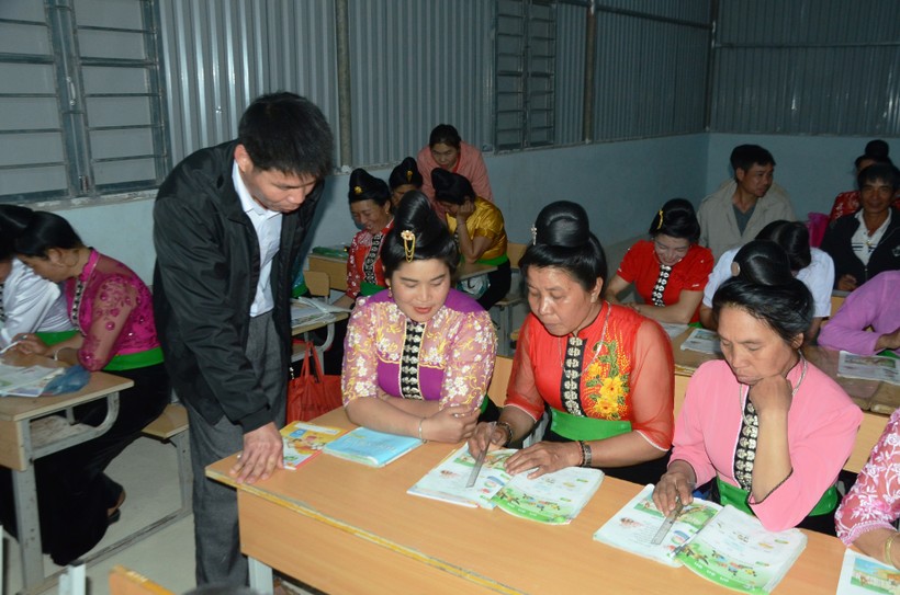 Giáo viên Trường PTDTBT Tiểu học Luân Giói hỗ trợ học viên lớp xóa mù chữ tại bản Na Cai.