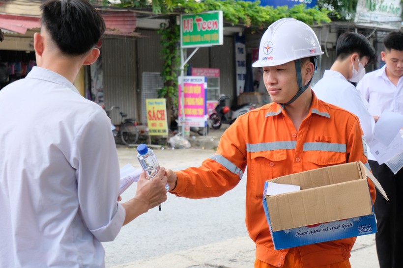 Tình nguyện viên "áo cam" phát nước miễn phí cho thí sinh tại điểm thi Trường THPT Triệu Quang Phục, Hưng Yên.