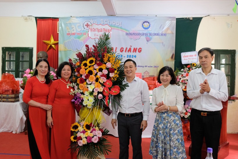 Đại diện Hội Chữ thập đỏ TP Hà Nội trao tặng hoa chúc mừng Trường PTCS Dân lập dạy trẻ câm điếc Hà Nội. ảnh 1