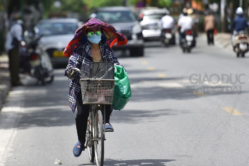 Nắng nóng gay gắt, nhiều người dân kín mít ra đường để tránh nắng.