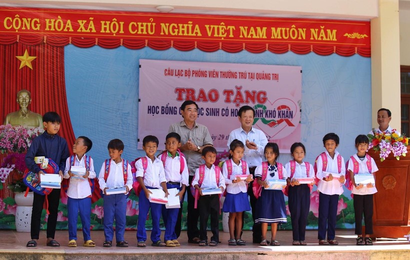 Lãnh đạo Sở GD&ĐT Quảng Trị và đại diện Câu lạc bộ phóng viên thường trú tại Quảng Trị trao học bổng đến các em học sinh. 