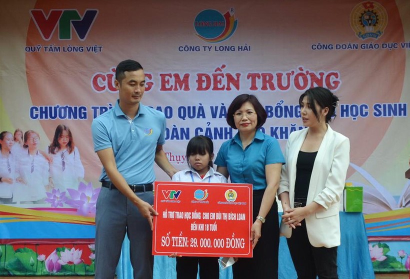 Phó Chủ tịch Công đoàn Giáo dục Việt Nam Đặng Hoàng Anh trao học bổng cho em Bùi Thị Bích Loan.