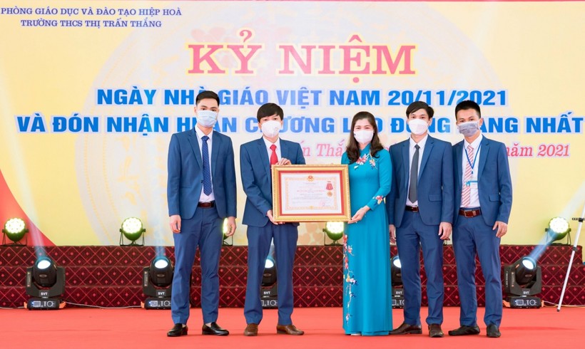 Thừa ủy quyền của Chủ tịch nước, bà Lâm Thị Hương Thành trao Huân chương Lao động hạng Nhất cho Nhà trường.