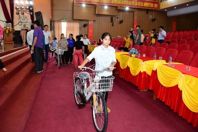 Học sinh nghèo vui mừng bên chiếc xe đạp mới được trao tặng.