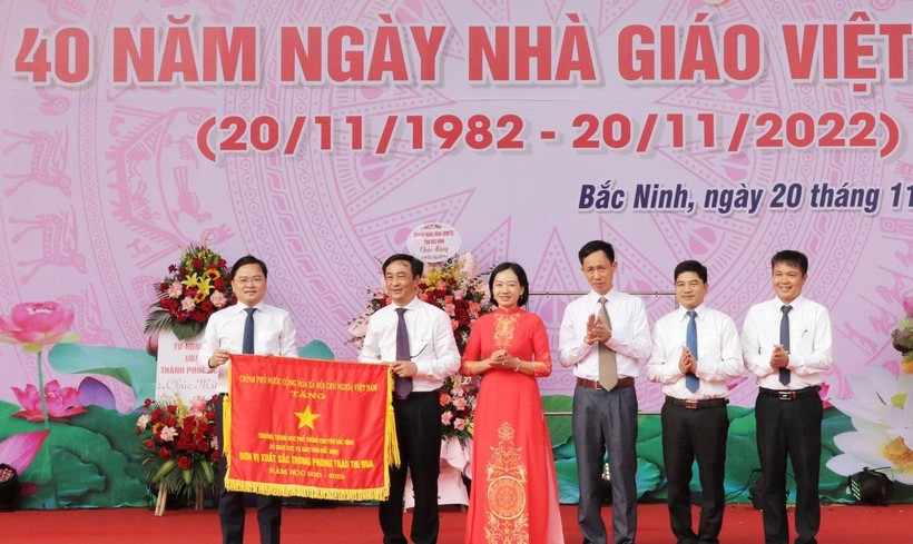 Thừa ủy quyền, Bí thư Tỉnh ủy Bắc Ninh - Nguyễn Anh Tuấn (ngoài cùng bên trái) trao Cờ thi đau của Chính phủ cho Trường THPT Chuyên Bắc Ninh.