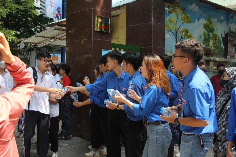 Tình nguyện viên tặng nước uống cho thí sinh dự thi.