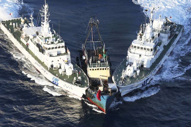 Hai tàu tuần tra của Lực lượng bảo vệ Bờ biển Nhật Bản áp sát một chiếc thuyền được cho là xâm nhập vào vùng biển của Nhật Bản ngoài khơi đảo Uotsuri, quần đảo Senkaku/Điếu Ngư. Ảnh: Businessweek.com