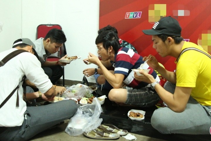 Hoài Linh ngồi bệt ăn cơm hộp cùng các diễn viên trẻ trong hậu trường