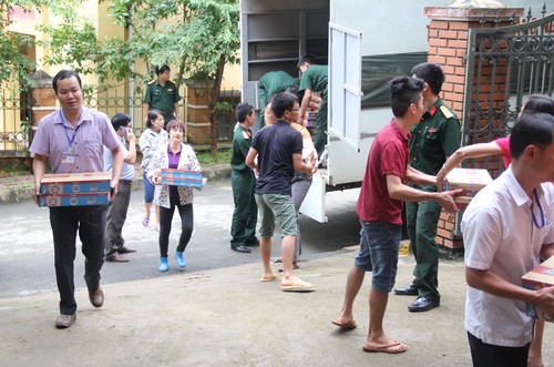 Các cán bộ, giáo viên vận chuyển sữa từ xe về phòng GD&ĐT huyện Mù Cang Chải