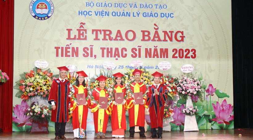 GS.TS Phạm Quang Trung, Giám đốc Học viện Quản lý giáo dục (ngoài cùng bên phải) và PGS.TS Trần Hữu Hoan, Phó Giám đốc Học viện (ngoài cùng bên trái) trao bằng tốt nghiệp cho các tân tiến sĩ.