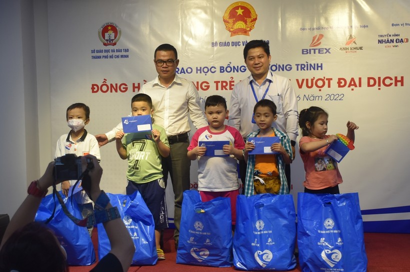 Ông Nguyễn Đắc Lực (Phó Tổng giám đốc Tập doàn BITEX) và ông Hồ Tấn Minh (Chánh văn phòng Sở Giáo dục và Đào tạo Thành phố Hồ Chí Minh) trao học bổng, quà cho các em học sinh.