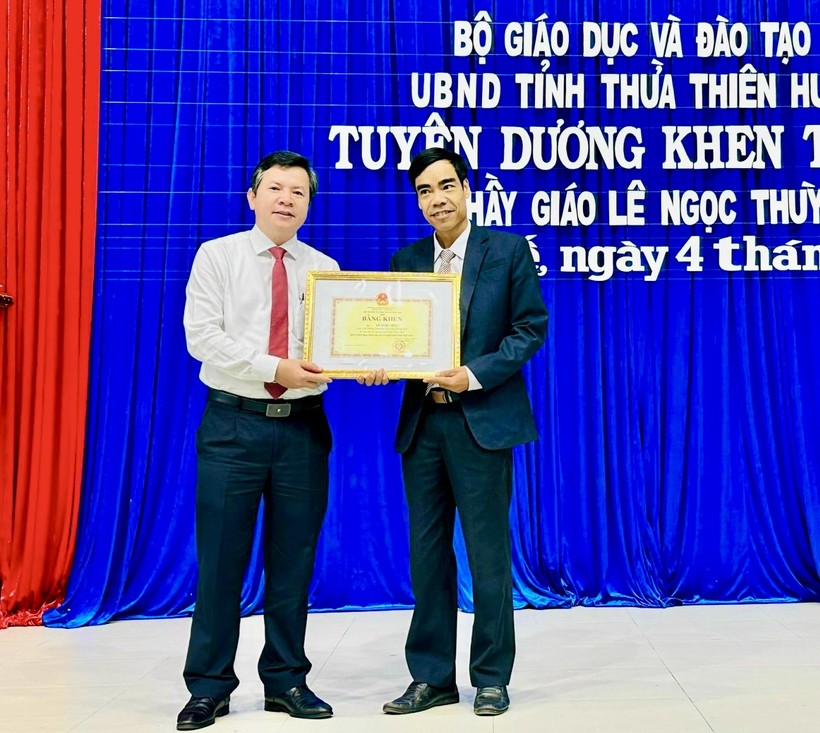 Ông Nguyễn Tân (bên trái) - Giám đốc Sở GD&ĐT tỉnh Thừa Thiên - Huế thừa ủy quyền trao Bằng khen của Bộ GD&ĐT và UBND tỉnh cho thầy giáo Lê Ngọc Thùy.