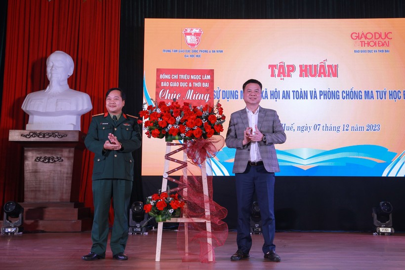 Nhà báo Triệu Ngọc Lâm (phải) - Tổng Biên tập Báo Giáo dục và Thời đại tặng hoa chúc mừng chương trình tập huấn.