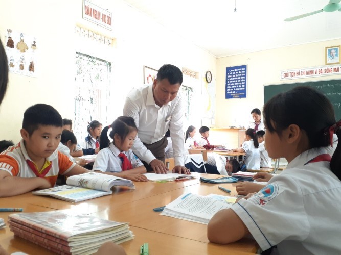 Thầy giáo Trần Văn Xuyên thăm hỏi học sinh.